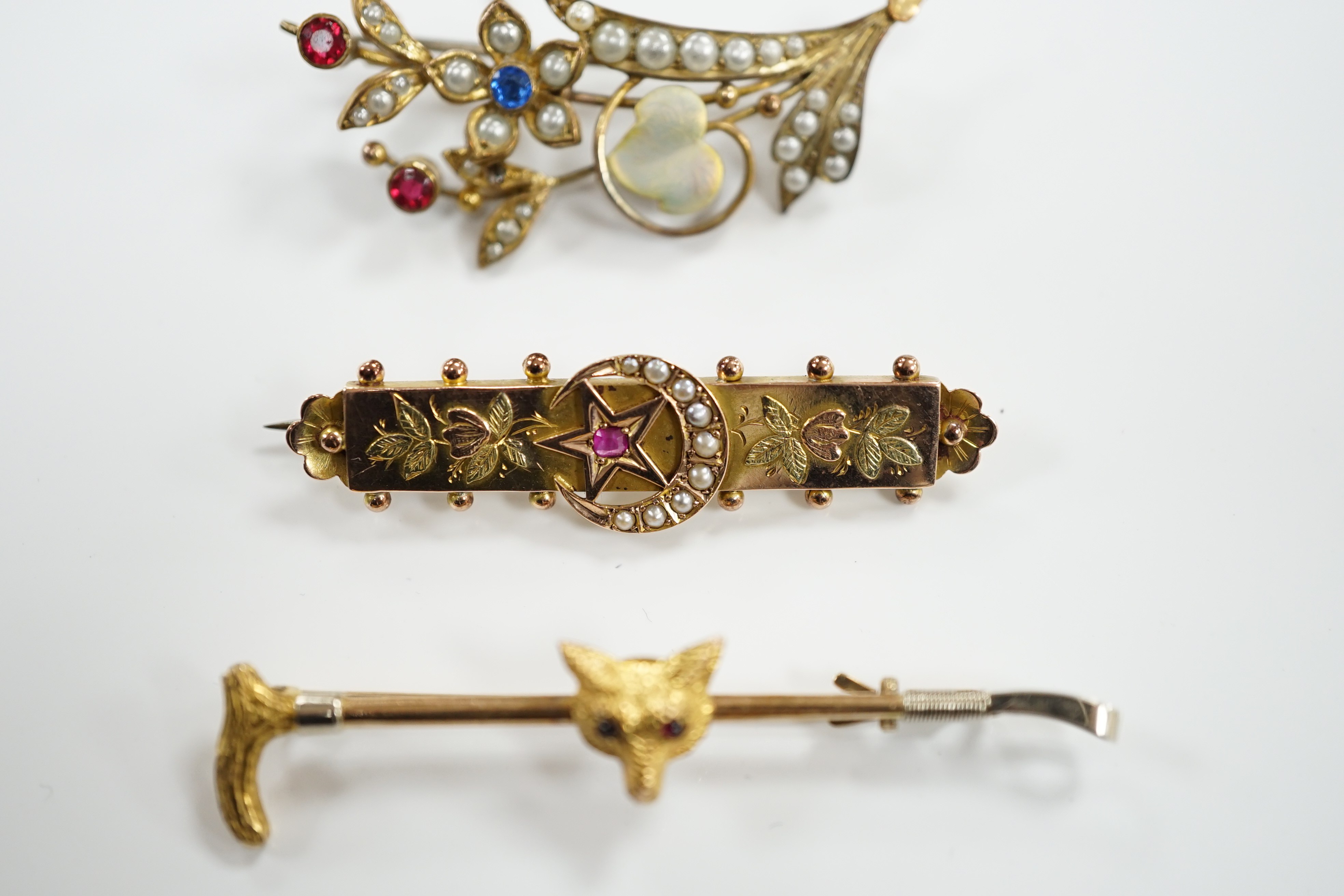 A 9ct and gem set fox head and riding crop bar brooch, 56mm, an Edwardian 9ct gold and gem set bar brooch and a rolled gold bar brooch.